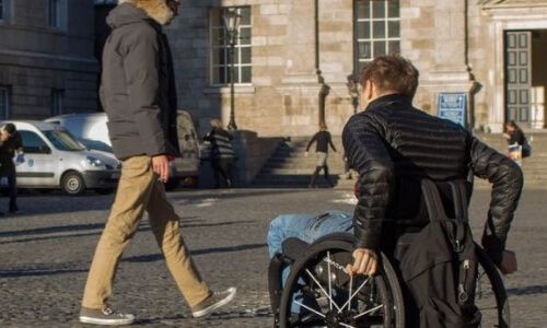 a person in a wheelchair crossing Trinity's Parliament Square