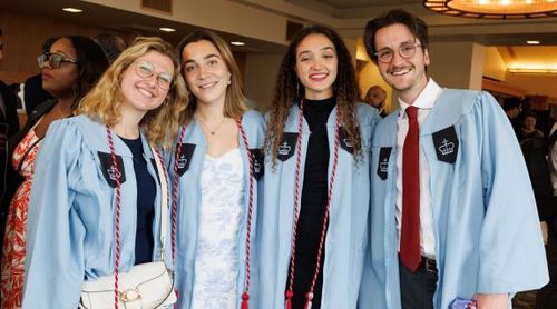 Four Dual BA students in graduation robes.