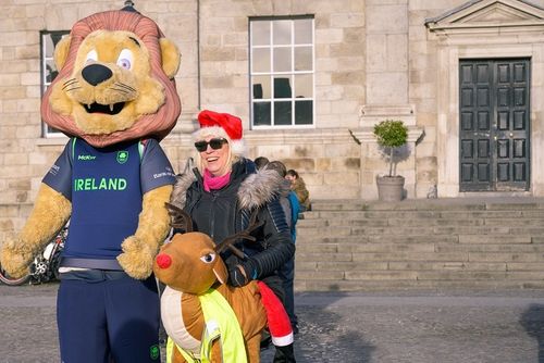 Reindeer Run 3K 2024 showing Lunn the Lion with Michelle Tanner in a reindeer outfit outside the Dining Hall, Trinity College Dublin
