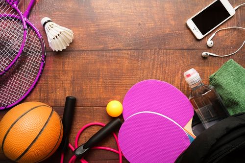 Mixed sports equipment on a wooden surface. Credit: Freepik