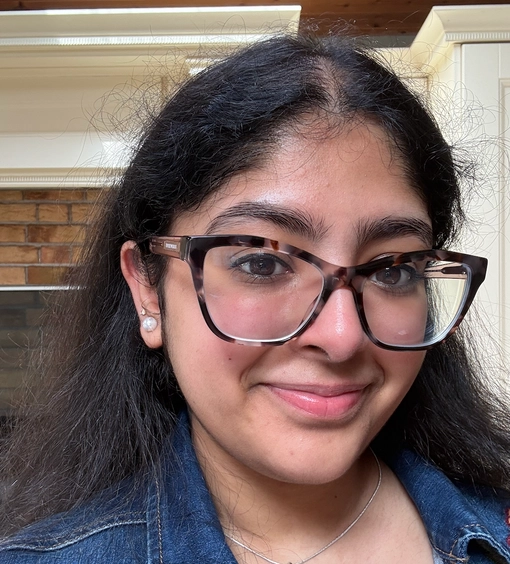 Student with long black hair wearing glasses
