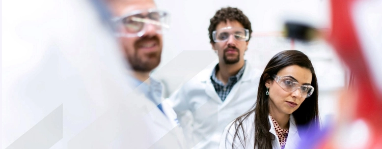 Three researchers wearing white lab coats