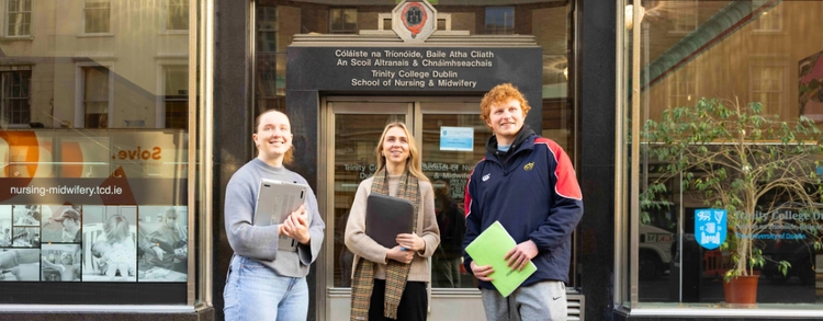 Three students outside the School of Nursing & Midwifery building