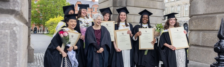 Students and Head of School pictured under the Campanile at 2026 MPhil Graduation