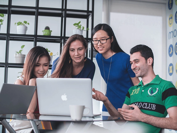 Students sitting around a laptop