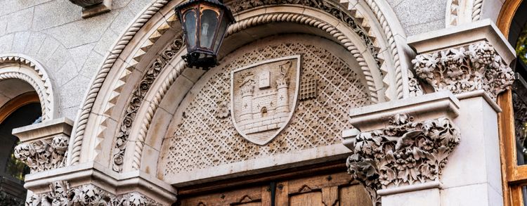 A close up image of the arch over the door of the Museum Building in Trinity College Dublin. The arch has an an engraving of Trinity's crest on it