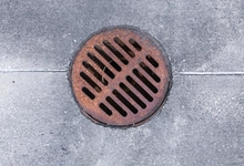 An image of a storm drain on a paved street