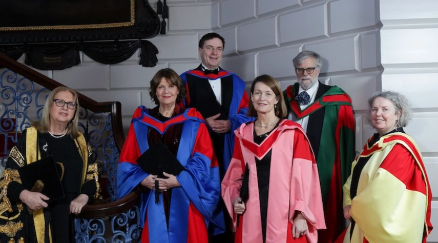 Group of all honorary doctoral recipients on 1.12.23 including Fergus Sheil standing in the middle top on staircase, flanked by Chancellor Mary McAleese and Provost Linda Doyle