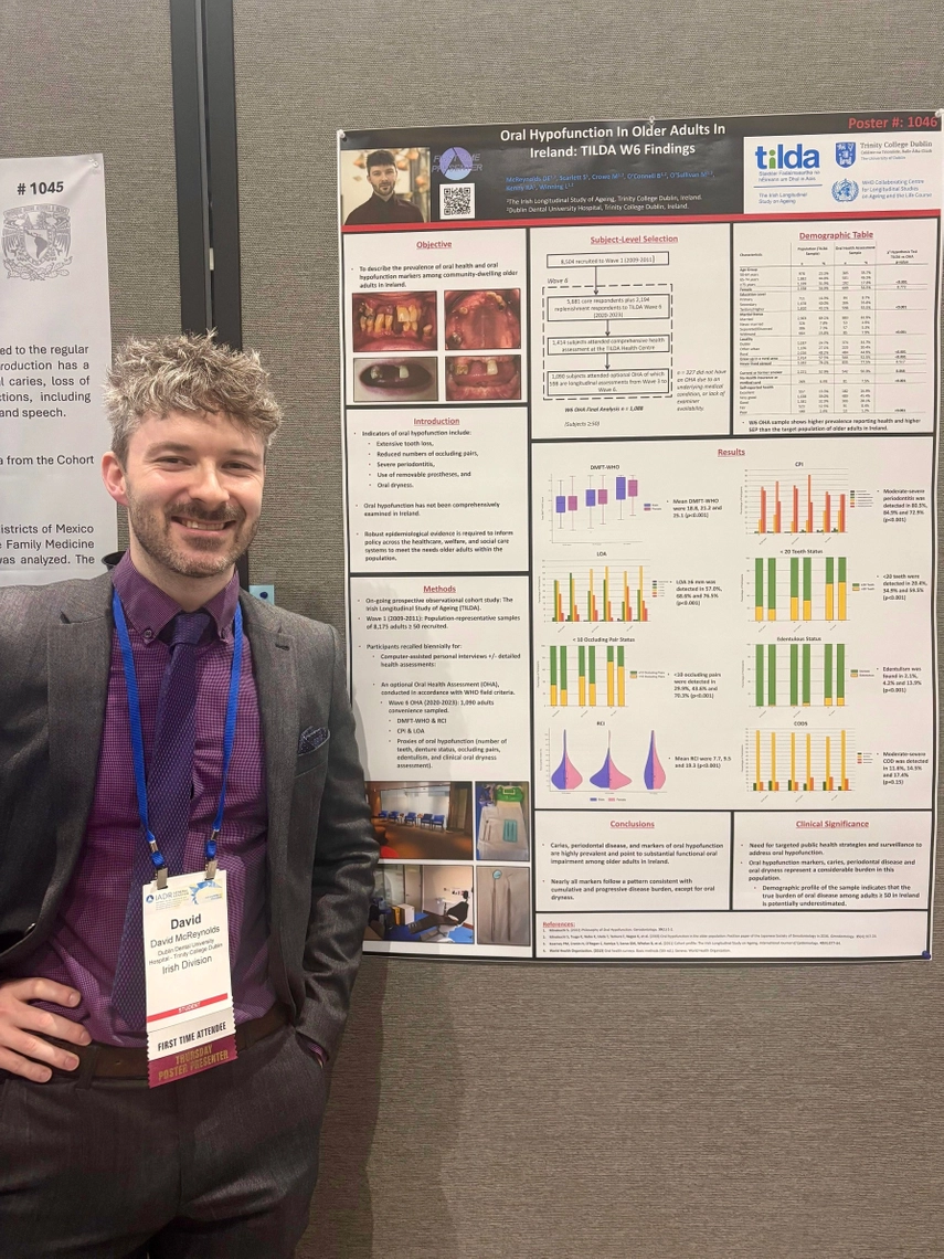 Dr David McReynolds standing in front of TILDA poster presentation at the IADR Conference in San Diego, California