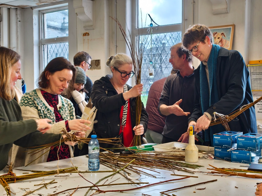 a group of Trinity staff producing St Brigid's crosses from willow trees