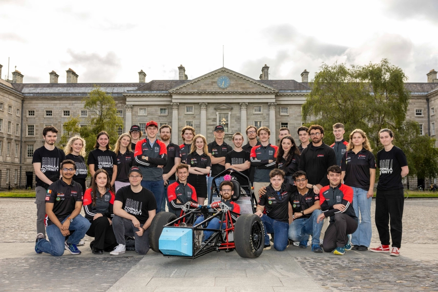 Formula Student Competition Team stood outside Trinity College with their single seater race car model