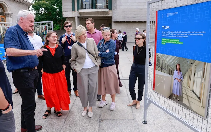 A group of people discusses a poster