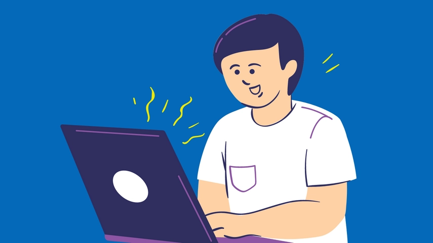 A picture of a person sitting by a laptop and smiling