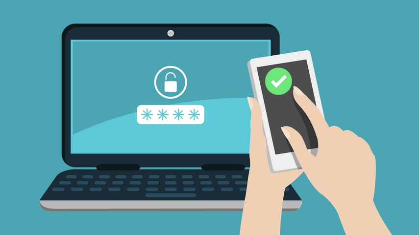 Laptop with sign in screen and person approving access via their mobile phone.