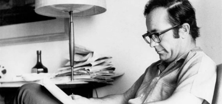 Rodolfo Walsh seated reading through papers.
