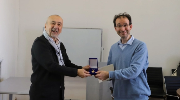 A man presents a medal to Prof Martin Worthington.