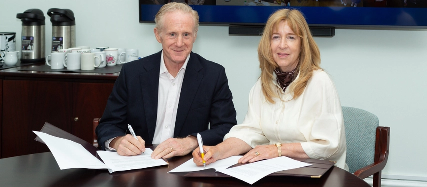 Two people signing a document