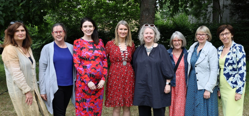 8 women smiling for a photo.