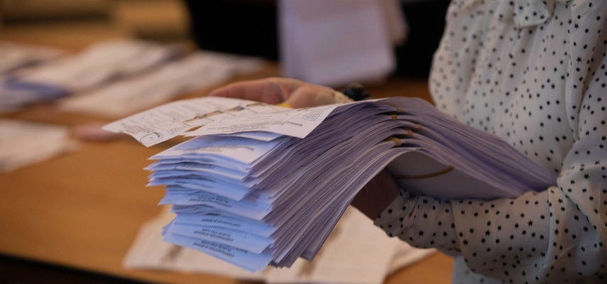 Image of a woman counting ballots.