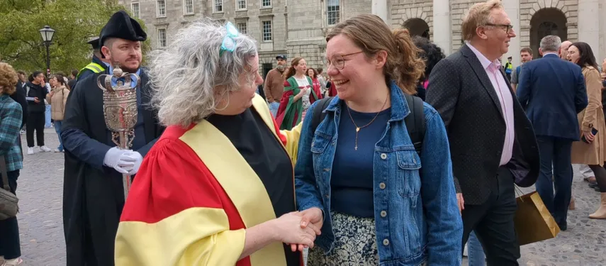 Provost shakes hands with Joy Byrne, a Scholar