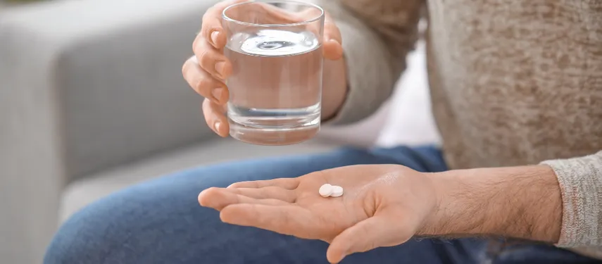 Man taking psychiatric medicine with a glass of water