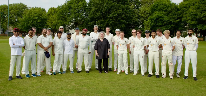 Large group photo of Linda with the two Cricket teams. The teams are all dressed in white, with the student team standing on the right, and the staff team on the left.