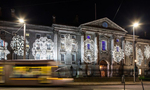 The front entrance building to Trinity illuminated in festive lights.