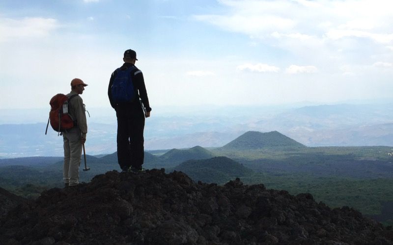 Researchers survey the scene with a volcano in the distance. Image credit: Dr Teresa Ubide.