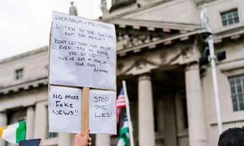 Image of protest poster being held up at a protest.