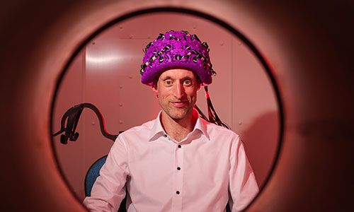 Image of Professor Redmond O'Connell waering the new OPM-MEG scanner.