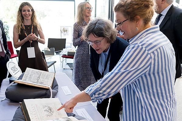 Image of people looking at a book at the Joint UCD TCD biennial conference of the Society for Italian Studies.