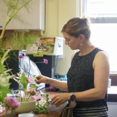 Female figure in photo setting up workshop space for flower arranging