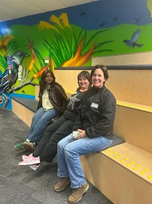 Student sitting beside 2 women