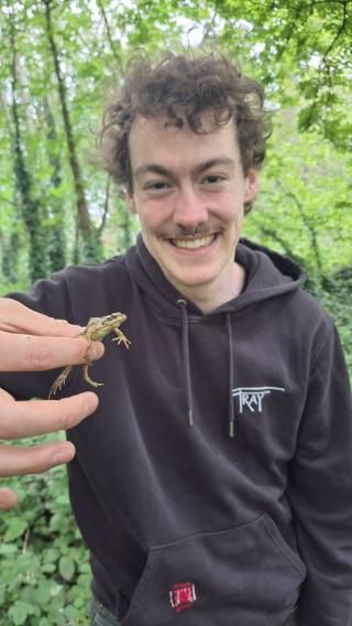 Student holding up a bug