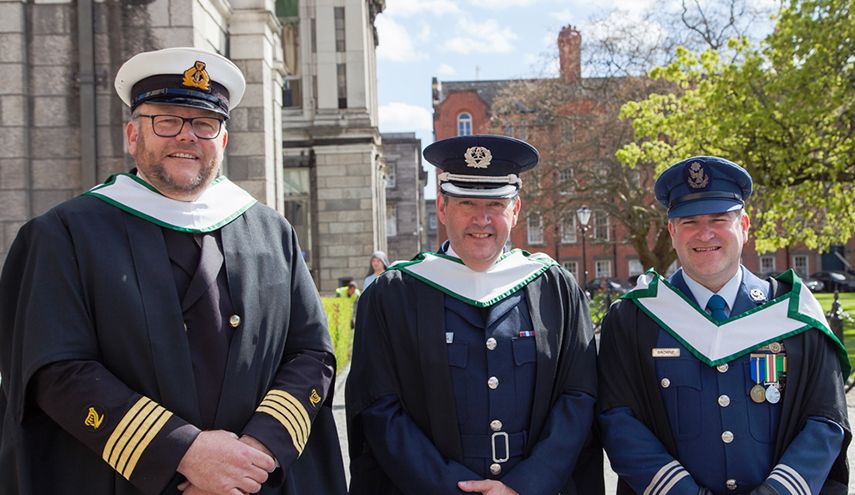 three graduation students of CIHS Course in cap and gown