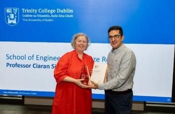 2 people standing together holding a certificate