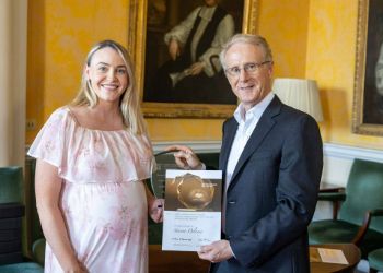 Two people standing beside each other holding a glass award