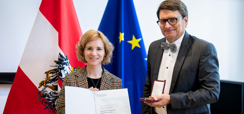 Clemens Ruthner accepting the Honorary Cross for Science and the Arts from the hands of Austrian Minister of Science and Research, Eva-Maria Holzleitner.