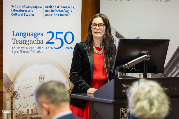 Professor Mary Cosgrove standing at a podium at the Opening Ceremony for Languages 250 at Trinity.