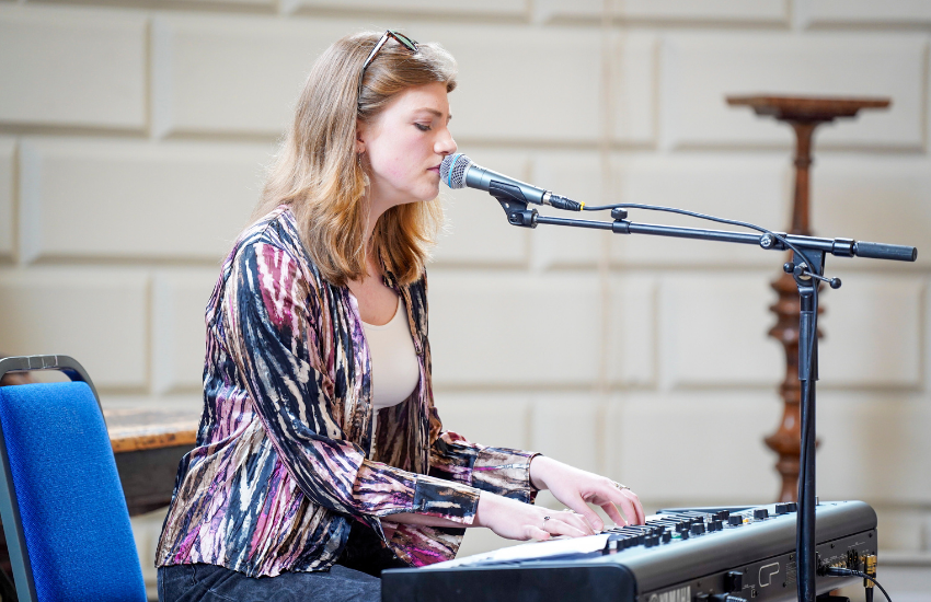 Gemma Cox playing a keyboard and singing at the Languages Alumni Summer Social.