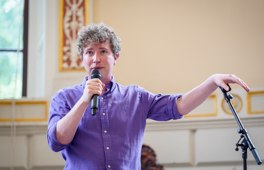 Comedian Michael Fry speaking to attendees at the Languages Alumni Summer Social in the Exam Hall, 5 June 2026.