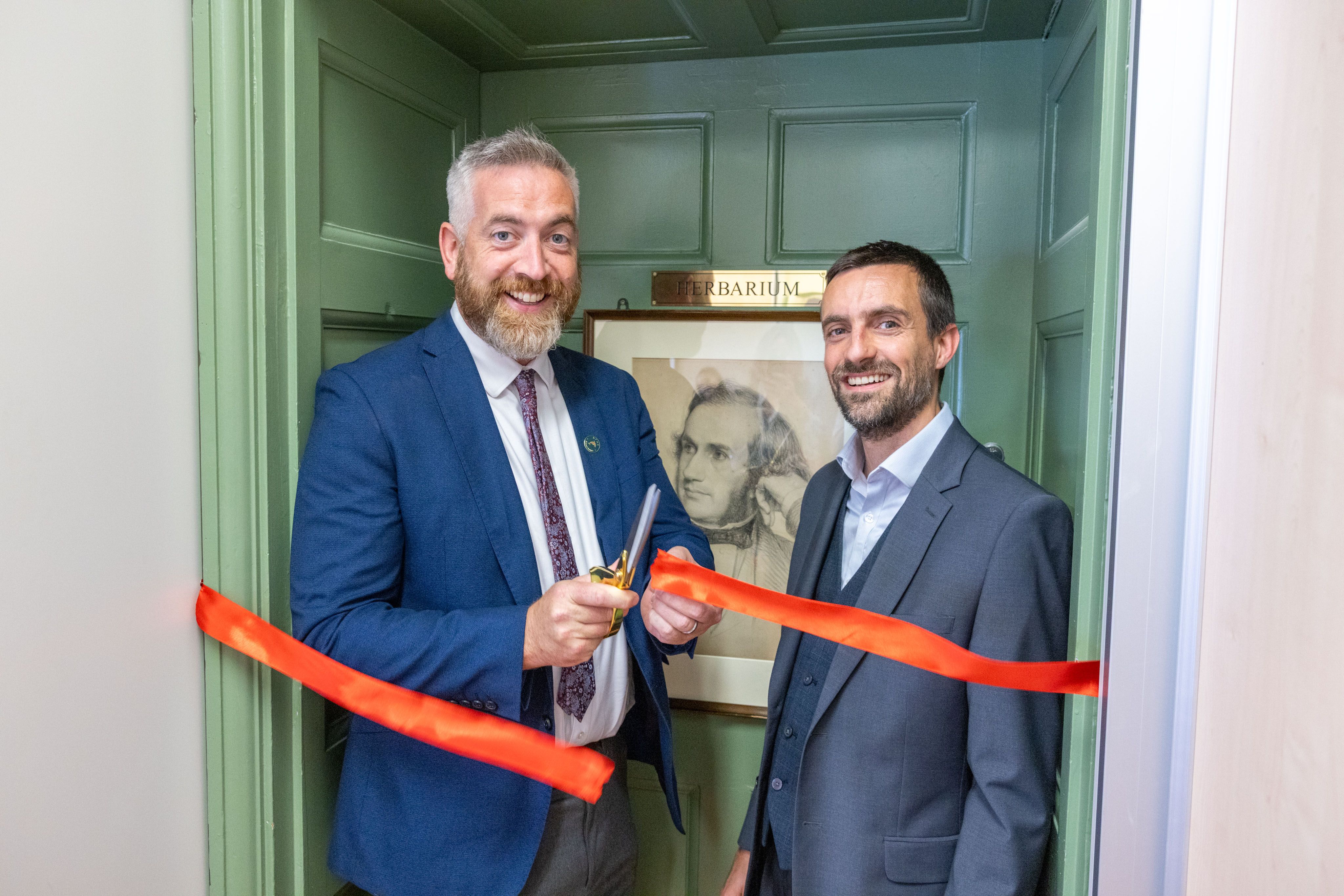 Minister O' Sullivan and Curator Peter Moonlight cut the ribbon to Herbarium Door