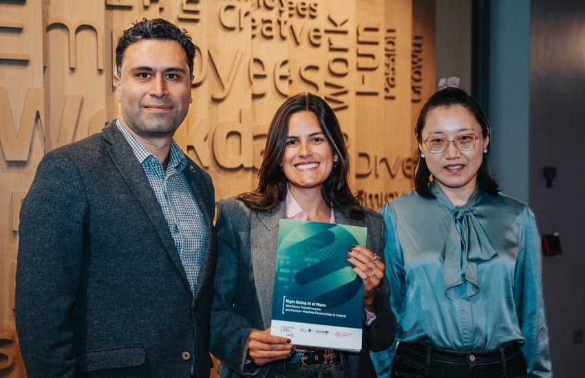 A man and two women pose with a report