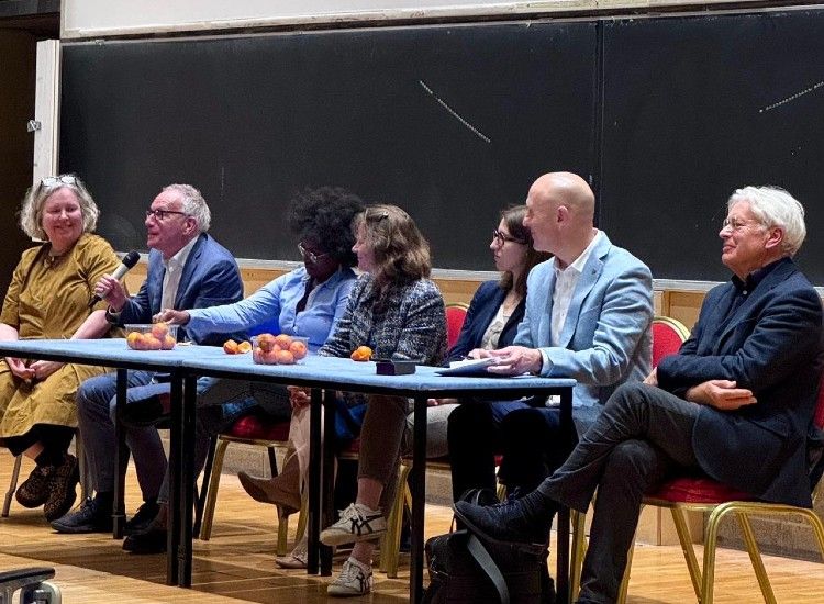 A panel of people address an event