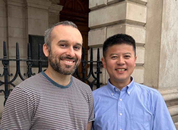 Two men pose, smiling