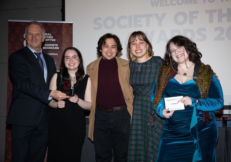 A group of people stands smiling at the camera