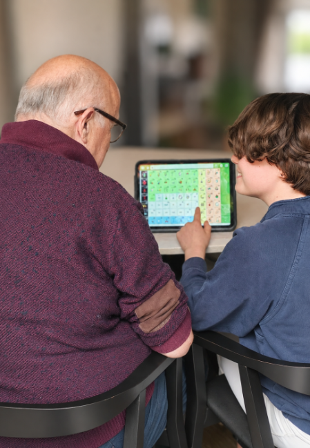 A child and grandfather look at a tablet