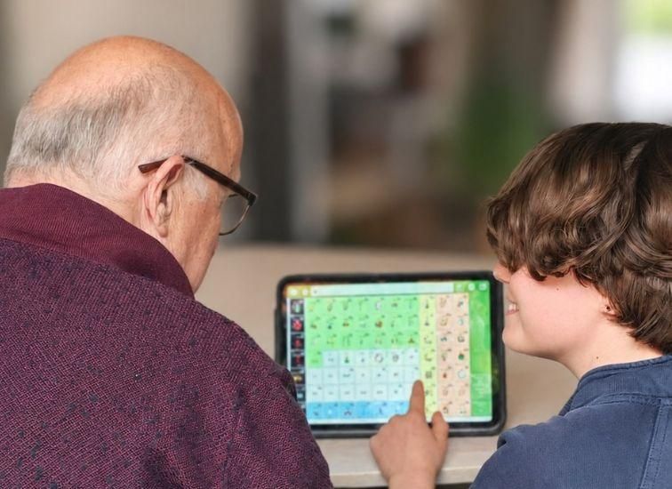 Grandfather and child look at the Geabaire tool on a tablet