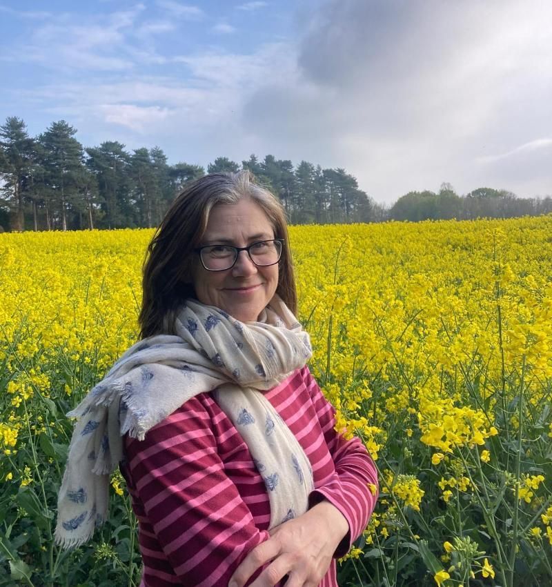Prof. Jane Stout standing by a field of oil seed rape on a sunny day