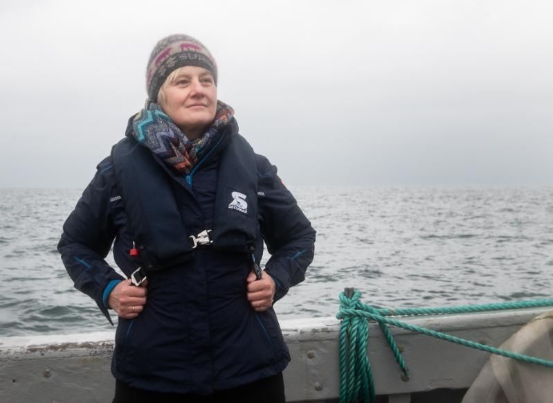 Prof Karen Wiltshire in a dark coat, standing on a boat on the sea.